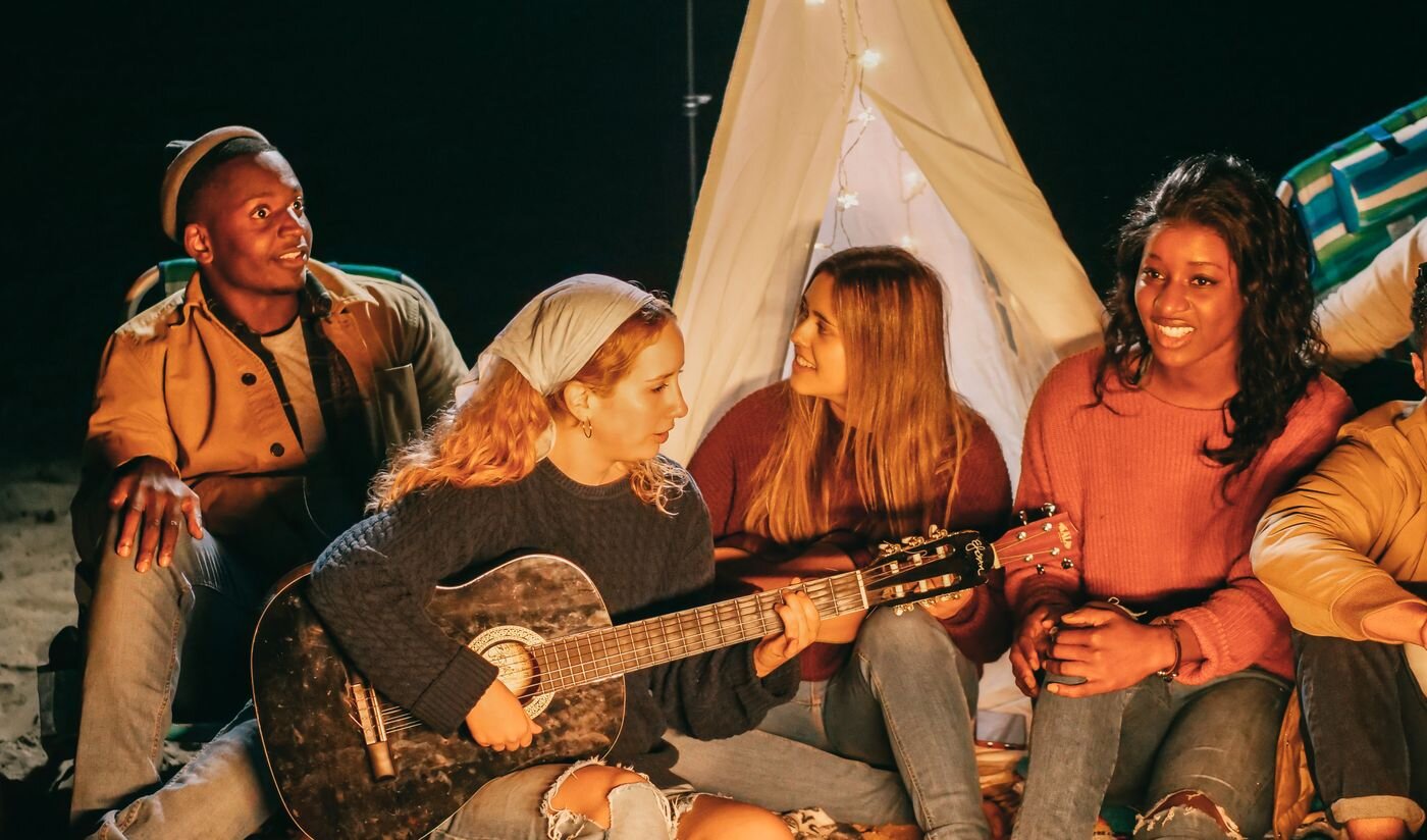 Friends gathered around a bonfire at night