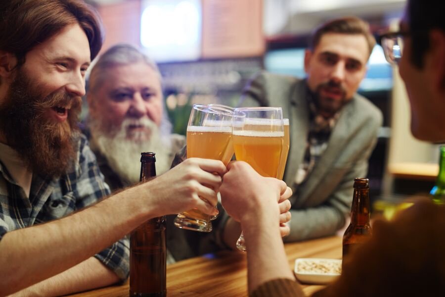 Friends toasting pints in a cosy pub